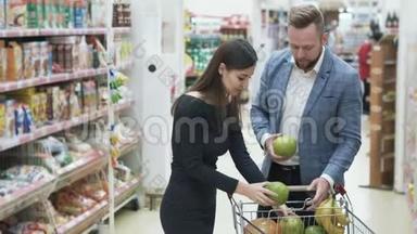 正面视频年轻夫妇，女人在超市用水果做滑稽的脸